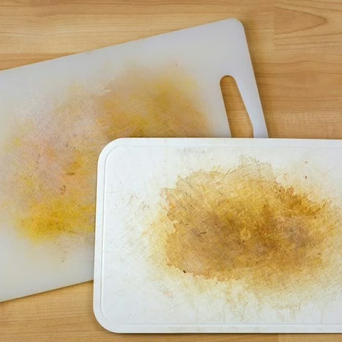 Two stained and scarred white plastic cutting boards