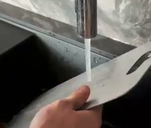 Rinsing the titanium board under the tap — a quick rinse is enough